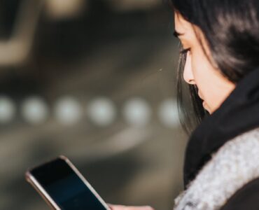 woman using smartphone on city street