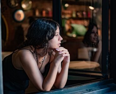 beautiful woman looking out of window in bar