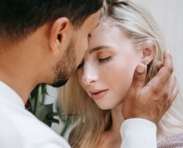 a man tucking a woman s hair behind her ear